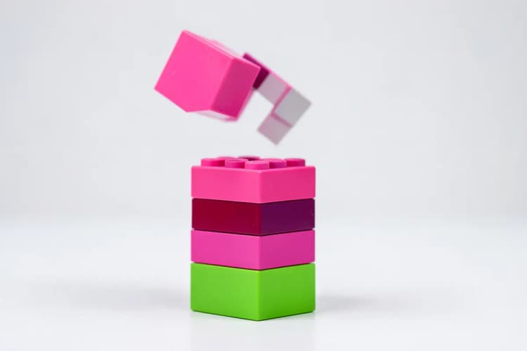 Uma pilha de blocos de construção coloridos com alguns blocos caindo, simbolizando erros em uma campanha.